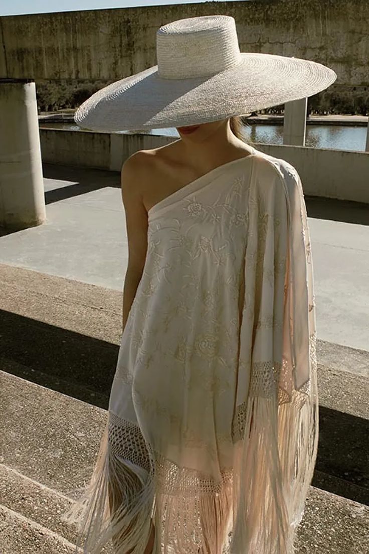 Vestido tipo mantón crema con bordados y pamela de paja